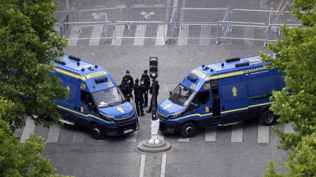 Des bus de la gendarmerie sont stationnés en travers de la route avant le passage du bus du Paris Saint-Germain sur l’avenue des Champs-Élysées à Paris, le 1er juin 2025, au lendemain de la victoire du PSG en finale de la Ligue des champions 2025 contre l’Inter Milan à Munich.