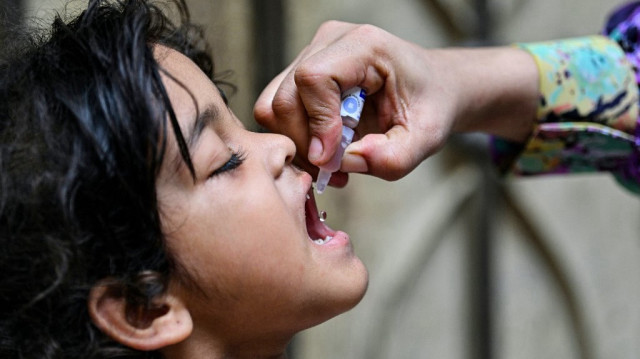 Un agent de santé administre des gouttes contre la polio à un enfant pour le vacciner, le premier jour d'une campagne nationale d'éradication du poliovirus qui dure une semaine, à Karachi, le 26 mai 2025.