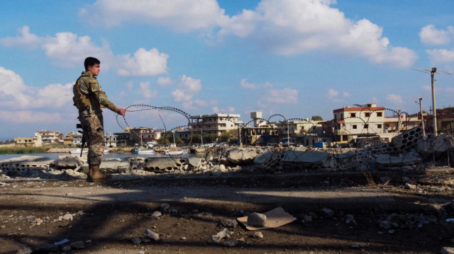 Un soldat libanais installe des barbelés à la frontière libano-syrienne à Al-Arida, le 9 décembre 2024.