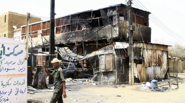 Un soldat de l'armée soudanaise passe devant un bâtiment endommagé par la guerre à Salha, au sud d'Omdurman, deux jours après que l'armée soudanaise l'ait repris aux forces paramilitaires de soutien rapide (RSF), le 22 mai 2025.