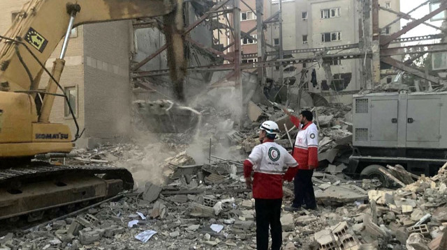 Cette photo fournie par le Croissant-Rouge iranien le 19 juin 2025 montre des membres de leurs équipes de secours en train de déblayer les débris d'un bâtiment détruit lors d'une attaque israélienne à Téhéran.