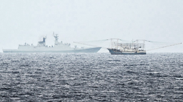 Cette photo prise le 6 juin 2025 montre un navire des garde-côtes chinois (à gauche) et un navire près de l'île de Thitu occupée par les Philippines (connue sous le nom de Pag-asa aux Philippines), photographiés depuis le navire de la marine philippine "BRP Andres Bonifacio" au cours d'une patrouille maritime dans la mer de Chine méridionale contestée.