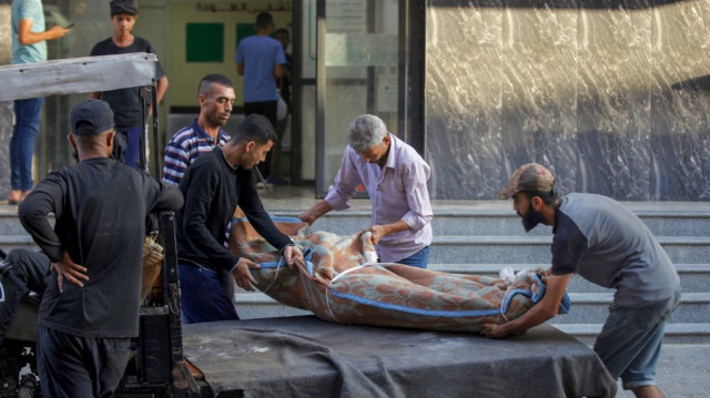 Des personnes marchent avec leurs affaires alors qu'elles évacuent leurs maisons endommagées, un jour après qu'un missile iranien ait frappé une zone, à Holon dans le centre d'Israël près de Tel Aviv, le 20 juin 2025.