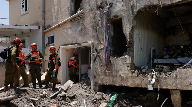 Des soldats israéliens et des secouristes vérifient les dommages causés à un bâtiment par une frappe iranienne à Beit She'an, le 21 juin 2025, dans le cadre de l'échange de tirs entre l'Iran et Israël.