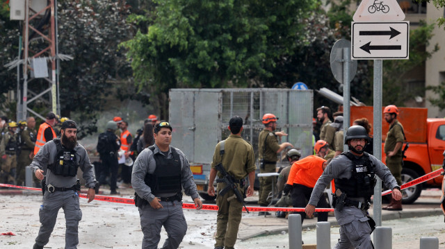 Les forces de sécurité israéliennes et les premiers intervenants se rassemblent sur le site d'une frappe iranienne qui a touché un immeuble résidentiel dans le quartier de Ramat Aviv à Tel Aviv, le 22 juin 2025. Au moins 16 personnes ont été blessées et au moins un impact a été signalé dans le centre d'Israël après que l'Iran a lancé deux vagues de missiles sur le pays à la suite du bombardement de ses sites nucléaires par les États-Unis, selon les services de secours et les rapports.