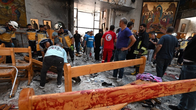 Des personnes et des secouristes inspectent les dégâts sur le site d'un attentat suicide à l'église Saint Elias dans le quartier de Dwelaa à Damas, le 22 juin 2025.