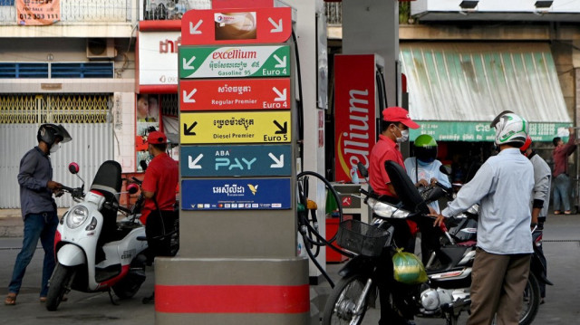 Des automobilistes font le plein d'essence dans une station-service de Phnom Penh au Cambodge.