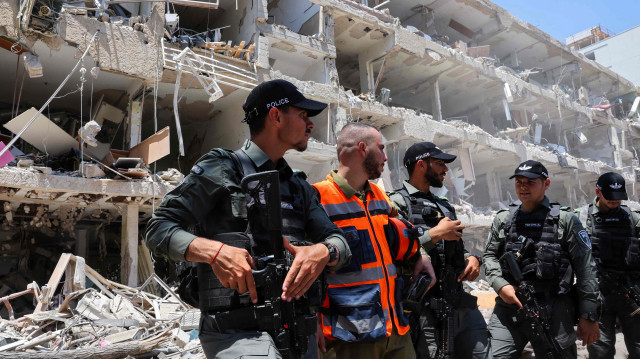 Des forces de sécurité israéliennes montent la garde sur le site d’une frappe iranienne ayant touché un quartier de la zone de Ramat Aviv, à Tel-Aviv, le 22 juin 2025.