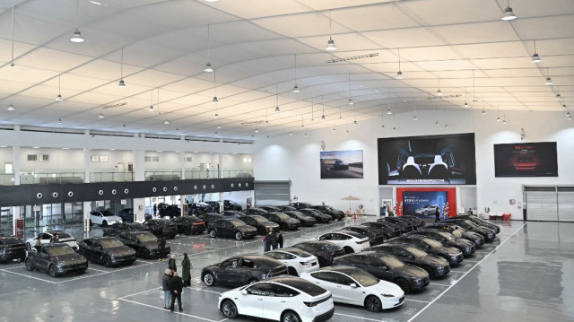 Des personnes vérifient les voitures Tesla Model Y lors d'une journée de livraison pour les acheteurs au centre de livraison Xiedao de Tesla à Pékin.
