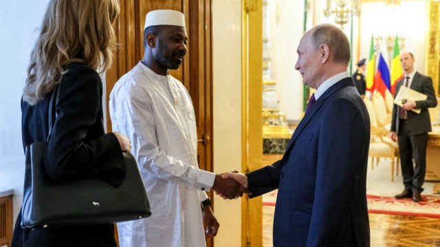 Sur cette photo de famille diffusée par l'agence d'État russe Sputnik, le président russe Vladimir Poutine et le chef de la junte malienne Assimi Goita se serrent la main après une cérémonie de signature faisant suite à leurs entretiens au Kremlin, à Moscou, le 23 juin 2025.