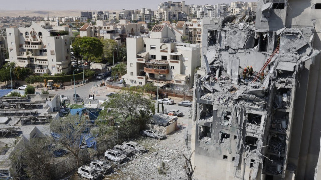 Des secouristes vérifient les dommages causés à un bâtiment par un tir de missile iranien à Beersheba, dans le sud d'Israël, le 24 juin 2025. Israël a déclaré le 24 juin avoir accepté la proposition de cessez-le-feu du président américain Donald Trump avec l'Iran, au 12e jour de guerre entre les ennemis.