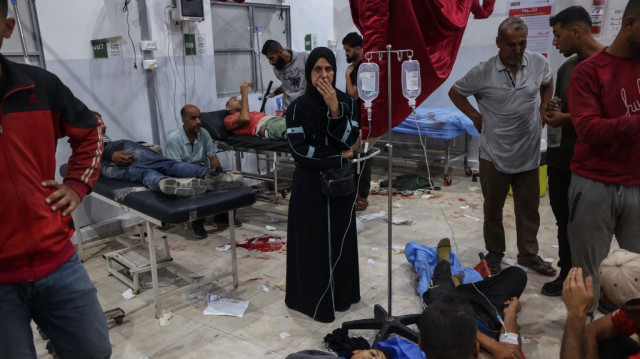 Une femme palestinienne regarde les personnes blessées par les tirs israéliens sur un point de distribution d'aide alimentaire mis en place par la Fondation humanitaire de Gaza (GHF) sur la route de Salaheddin, recevoir des soins à l'hôpital Al-Awda dans le camp de réfugiés de Nuseirat dans le centre de la bande de Gaza, le 24 juin 2025.
