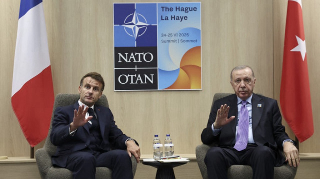 Le président français Emmanuel Macron (G) et le président turc Recep Tayyip Erdogan font un geste lors de leur rencontre en marge du sommet de l'Organisation du traité de l'Atlantique nord (OTAN) à La Haye, le 25 juin 2025.