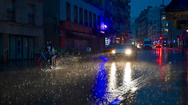 Un cycliste roule sous la pluie pendant un orage rue de Bagnolet, à Paris, le 25 juin 2025.
