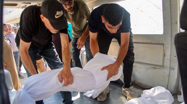 Des employés palestiniens de la morgue placent un corps dans un véhicule à l'extérieur de l'hôpital Al-Shifa dans la ville de Gaza, le 26 juin 2025, après que plusieurs personnes aient été tuées lors de frappes israéliennes pendant la nuit, dans le cadre du conflit actuel entre Israël et le groupe de militants palestiniens du Hamas.
