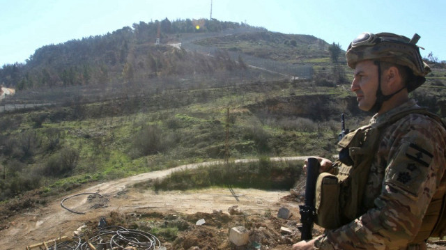 Un soldat de l'armée libanaise monte la garde dans le village méridional d'Adaisseh, en face du village israélien de Meskaf Am, à la frontière entre les deux pays, suite au retrait des troupes israéliennes de tous les points du Sud-Liban, à l'exception de cinq, le 18 février 2025.