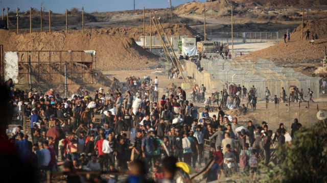 Des Palestiniens se rassemblent à un point de distribution d'aide mis en place par la Fondation humanitaire de Gaza (GHF), près du camp de réfugiés de Nuseirat, dans le centre de la bande de Gaza, le 25 juin 2025.
