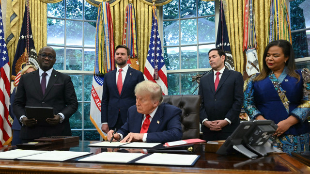 Le président américain Donald Trump signe une lettre adressée au président congolais Felix Tshisekedi pour le féliciter de l'accord de paix avec le Rwanda lors d'une réunion avec la ministre des Affaires étrangères de la République démocratique du Congo, Thérèse Kayikwamba Wagner (à droite), et le ministre des Affaires étrangères du Rwanda, Olivier Nduhungirehe (à gauche), dans le bureau ovale de la Maison Blanche à Washington, DC, le 27 juin 2025. Participent également à la réunion, de gauche à droite, le vice-président américain JD Vance et le secrétaire d'État américain Marco Rubio.