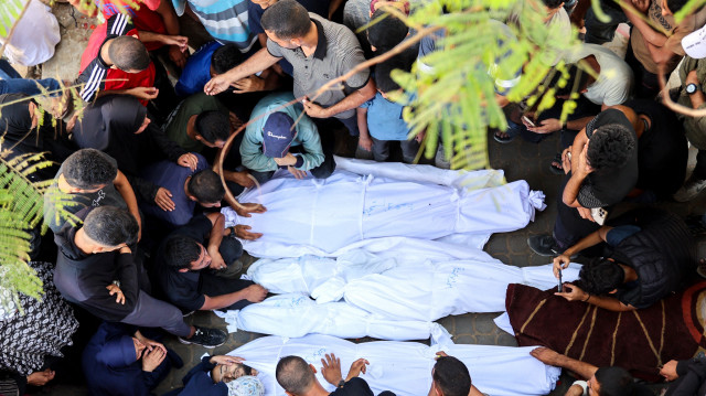 Des Palestiniens pleurent les corps de leurs proches tués lors des frappes israéliennes de la nuit, dans l'enceinte de l'hôpital Al-Shifa, dans le centre de la bande de Gaza, le 28 juin 2025.