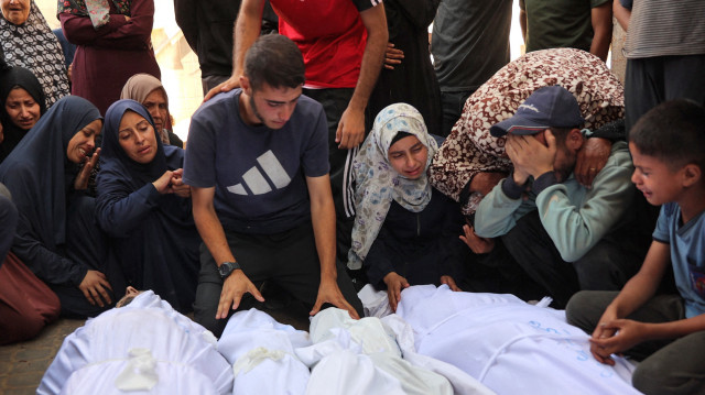 Des Palestiniens pleurent les corps de leurs proches tués lors des frappes israéliennes de la nuit, dans l'enceinte de l'hôpital Al-Shifa, dans le centre de la bande de Gaza, le 28 juin 2025.
