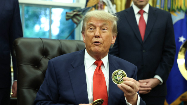 Le président américain Donald Trump tient une pièce de monnaie alors qu'il s'entretient avec le ministre des Affaires étrangères et de la Coopération du Rwanda, Olivier Nduhungirehe, et la ministre des Affaires étrangères de la République démocratique du Congo, Thérèse Kayikwamba Wagner, dans le bureau ovale de la Maison-Blanche, le 27 juin 2025. La rencontre a eu lieu alors qu'un accord de paix négocié par la Maison Blanche, qui espère mettre fin à un conflit dans l'est de la République démocratique du Congo, a été signé par des représentants des deux nations africaines.