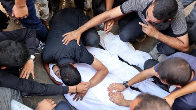 Des Palestiniens pleurent les corps de leurs proches tués lors des frappes israéliennes de la nuit, dans l'enceinte de l'hôpital Al-Shifa, dans le centre de la bande de Gaza, le 28 juin 2025.