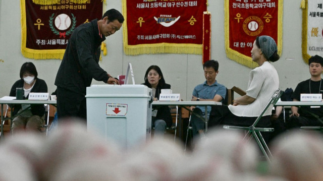 Un homme vote dans un bureau de vote, installé dans le centre d'entraînement d'un club de baseball, lors de l'élection présidentielle à Séoul, le 3 juin 2025.
