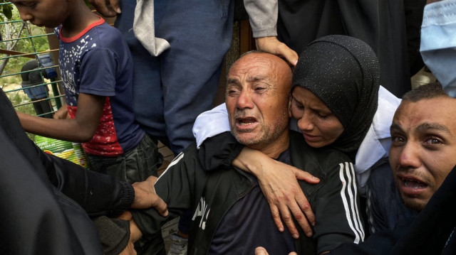 Des Palestiniens pleurent des membres de leur famille tués par des tirs israéliens alors qu'ils se rassemblent près d'un centre d'aide soutenu par les États-Unis dans la zone de Rafah, à l'hôpital Nasser, dans le sud de la bande de Gaza, le 3 juin 2025.