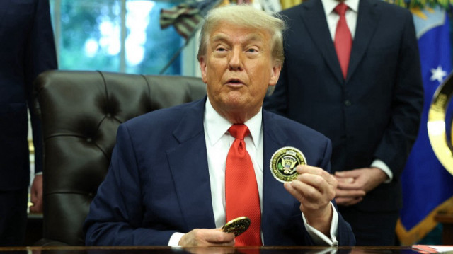  Le président américain Donald Trump tient une pièce de monnaie alors qu'il s'entretient avec le ministre des Affaires étrangères et de la Coopération du Rwanda, Olivier Nduhungirehe, et la ministre des Affaires étrangères de la République démocratique du Congo, Thérèse Kayikwamba Wagner, dans le bureau ovale de la Maison Blanche, le 27 juin 2025.