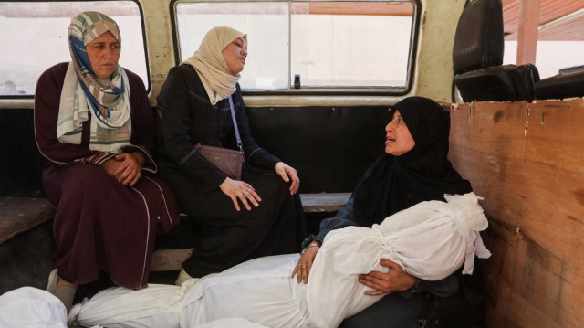 Une femme palestinienne tient le corps enveloppé d'un proche tué lors d'une frappe israélienne qui a visé la maison de la famille al-Bursh à Jabalia dans le nord de la bande de Gaza, le 2 juin 2025.