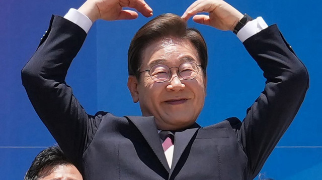 Le président sud-coréen Lee Jae-myung fait un geste du bras en direction de la population à l'extérieur de l'Assemblée nationale alors qu'il quitte les lieux après la cérémonie d'investiture à Séoul, le 4 juin 2025.