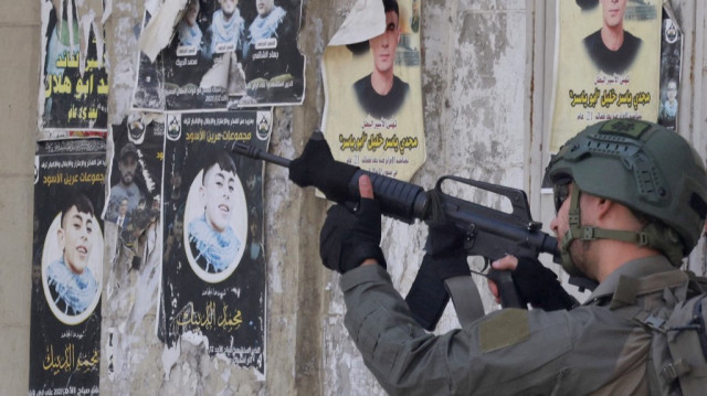 Un soldat de l'armée israélienne vise son fusil lors d'un raid au cœur de la ville palestinienne de Naplouse, en Palestine occupée, le 27 mai 2025.