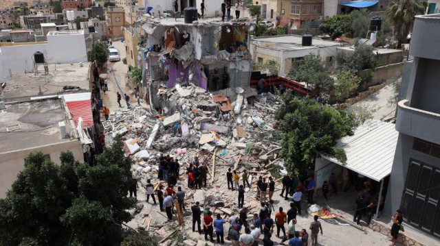 Les Palestiniens inspectent les dégâts autour d'un bâtiment détruit après que les troupes israéliennes l'aient assiégé et aient tué cinq hommes qui s'y trouvaient lors d'un raid de l'armée à Tammun, en Palestine occupée, le 15 mai 2025,