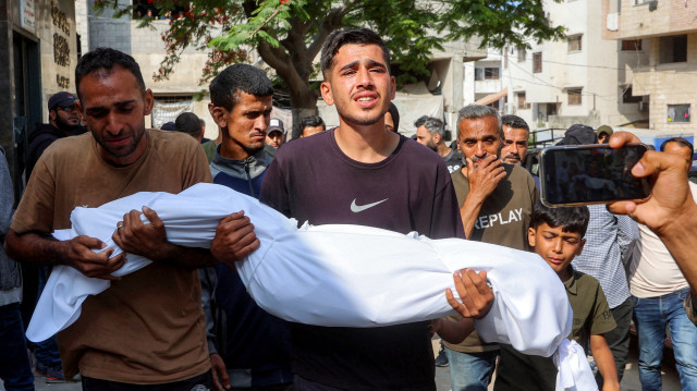 Des hommes portent le corps d'une victime tuée lors d'un bombardement israélien durant la nuit, pendant les funérailles à l'extérieur de l'hôpital al-Shifa dans la ville de Gaza le 4 juin 2025. Les bombardements israéliens du 4 juin ont tué au moins 16 personnes dans la bande de Gaza, dont 12 dans une seule frappe sur une tente abritant des personnes déplacées, a indiqué à l'AFP l'agence de défense civile du territoire palestinien.
