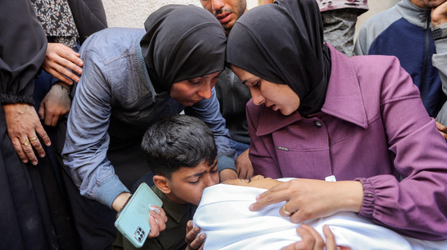 Un garçon embrasse le corps d'une victime tuée lors d'un bombardement israélien pendant la nuit, alors qu'il est bercé par une femme avec d'autres personnes en deuil à l'hôpital al-Shifa dans la ville de Gaza, le 4 juin 2025. Les bombardements israéliens du 4 juin ont tué au moins 16 personnes dans la bande de Gaza, dont 12 dans une seule frappe sur une tente abritant des personnes déplacées, a indiqué à l'AFP l'agence de défense civile du territoire palestinien.