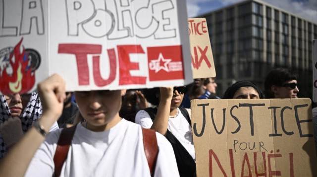 Des manifestants brandissent des banderoles sur lesquelles on peut lire "La police tue" et "Justice pour Nahel" lors d'un rassemblement marquant les deux ans de la mort de Nahel Merzouk, un jeune homme de 17 ans abattu à bout portant par la police lors d'un contrôle routier, à Nanterre, à l'ouest de Paris, le 27 juin 2025.
