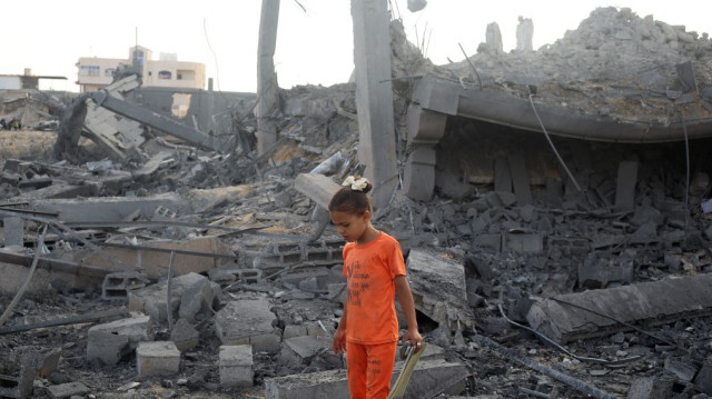 Une fillette palestinienne marche au milieu des décombres d'un bâtiment touché par une frappe israélienne dans le camp de réfugiés de Bureij, au centre de la bande de Gaza, le 10 juillet 2025.