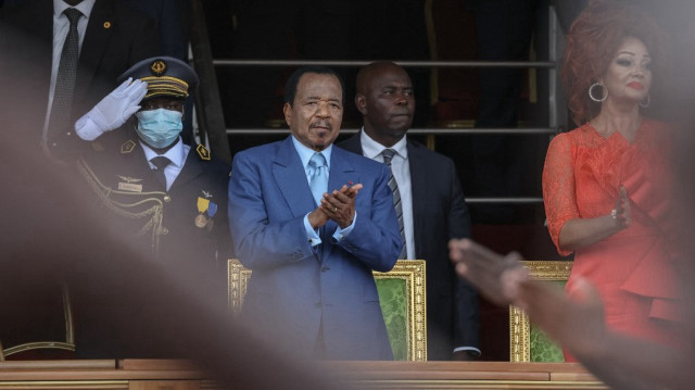 Le président camerounais Paul Biya (au centre) et son épouse Chantal Biya (à droite) applaudissent lors du défilé du 20 mai marquant la 51e célébration de la fête de l'unité à Yaoundé, le 20 mai 2023.