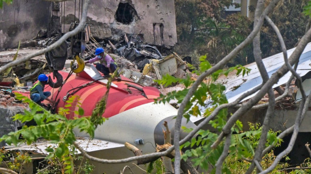 Des ouvriers retirant la queue de l'avion des débris après le crash du vol 171 d'Air India le 12 juin, photographiés dans un quartier résidentiel près de l'aéroport d'Ahmedabad le 14 juin 2025.