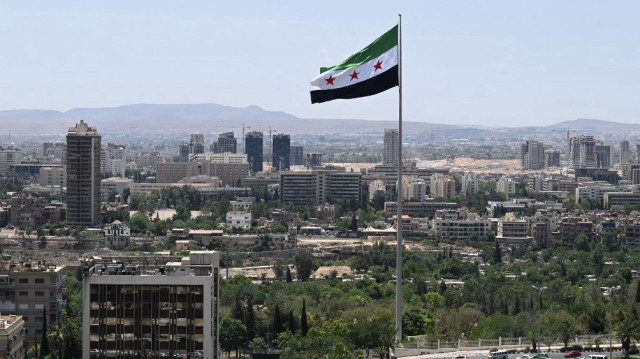 Un grand drapeau syrien flotte au-dessus du parc Tishreen à Damas, le 4 juin 2025.