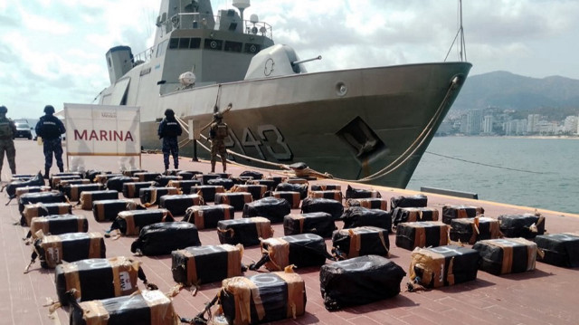 Cette photo diffusée par le ministère mexicain de la Défense nationale montre des membres de la marine gardant des paquets contenant 1,3 tonne de cocaïne saisis lors d'une opération menée au large des côtes de l'État de Guerrero (sud), à la base militaire d'Icacos, à Acapulco, dans l'État de Guerrero, au Mexique, le 13 mai 2025.
