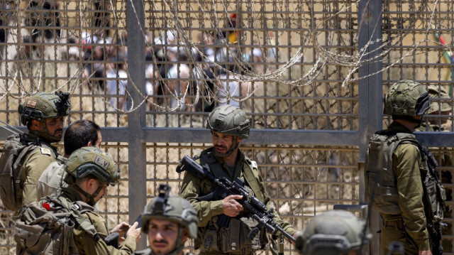 Les forces israéliennes se rassemblent le long de la ligne de démarcation alors que des membres de la communauté druze de Syrie se rassemblent de l'autre côté pour tenter de franchir la clôture de barbelés avec le plateau du Golan annexé par Israël, près de Majdal Shams, le 16 juillet 2025.