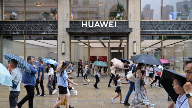 Des gens passent devant le magasin phare de Huawei Shanghai dans le district de Huangpu à Shanghai, le 23 juin 2025.