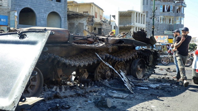 Des combattants druzes syriens marchent près d'un véhicule militaire endommagé, après que les forces gouvernementales syriennes se soient retirées du gouvernorat de Soueïda, le 17 juillet 2025.