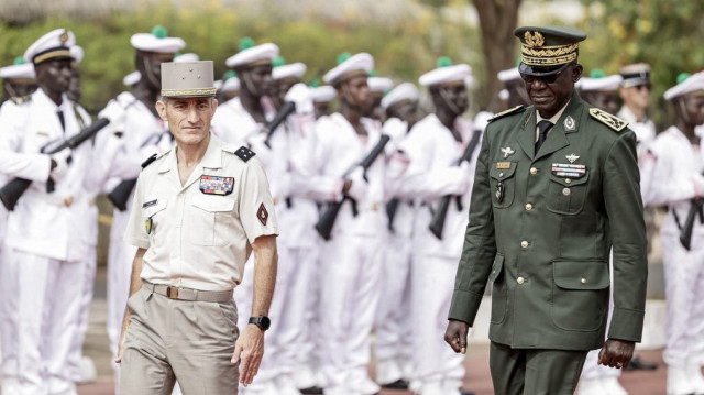 Le chef d'état-major général du Sénégal, le général Mbaye Cissé (à droite), et le général français Pascal Ianni (à gauche), qui commande les troupes françaises en Afrique, se dirigent vers un mât où le drapeau sénégalais sera hissé lors d'une cérémonie au cours de laquelle la France rendra le camp Geille, sa plus grande base dans le pays, et son aérodrome à l'aéroport de Dakar, à Dakar, le 17 juillet 2025.