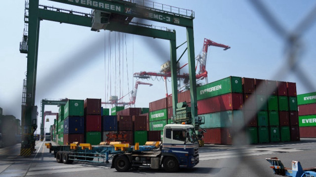 Un camion passe devant une pile de conteneurs au terminal de fret international du port de Tokyo, le 8 juillet 2025.