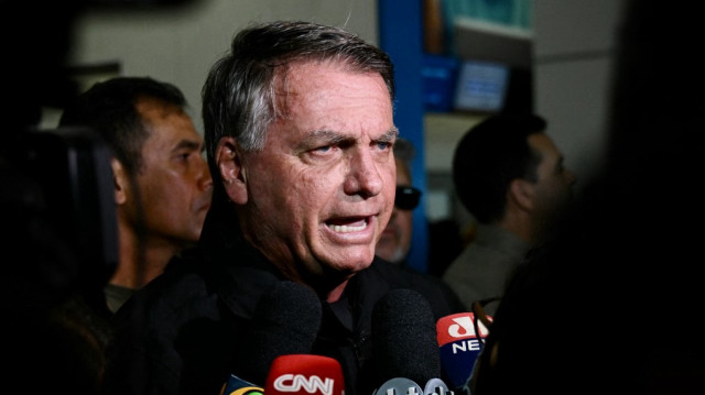 L'ancien président brésilien Jair Bolsonaro s'adresse aux médias après avoir accompagné son épouse, Michelle Bolsonaro, à bord d'un avion à destination des États-Unis afin qu'elle le représente lors de l'investiture du président élu Donald Trump, après qu'un juge brésilien ait rejeté sa demande de voyager à l'aéroport de Brasilia le 18 janvier 2025.