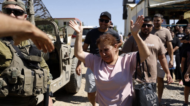Une femme druze syrienne qui s'est rendue la veille au village de Majdal Shams, sur le plateau du Golan annexé par Israël, fait ses adieux à ses proches alors qu'elle s'apprête à regagner la Syrie voisine, le 17 juillet 2025.