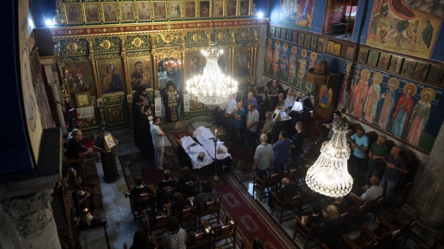 Des Palestiniens chrétiens assistent à la cérémonie funéraire de Saad Salameh et Foumia Ayyad, tués lors d'une frappe israélienne qui a touché l'église de la Sainte Famille dans la ville de Gaza, alors que l'archevêque Alexios de l'église Saint Porphyrius dirige la messe, le 17 juillet 2025.