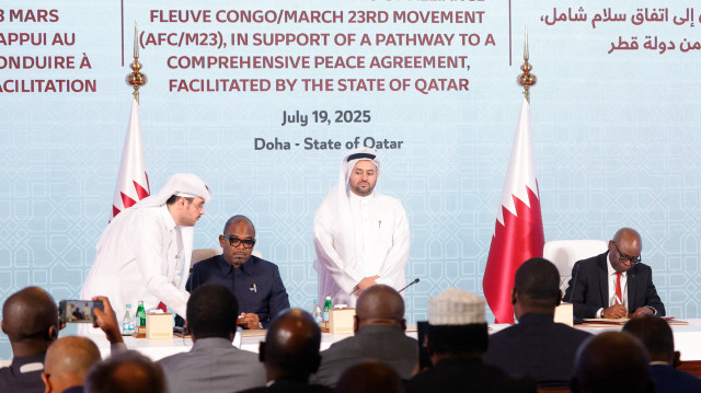 Le négociateur en chef du Qatar, Mohammed al-Khulaifi (C), se tient entre le médiateur de paix Sumbu Sita Mambu, haut représentant du chef de l'État de la République démocratique du Congo (RDC), et le secrétaire exécutif du groupe armé M23 soutenu par le Rwanda, Benjamin Mbonimp (D), alors qu'ils signent un accord de cessez-le-feu à Doha, le 19 juillet 2025, pour mettre fin aux combats qui ont dévasté l'est du pays, riche en minerais mais déchiré par le conflit. 